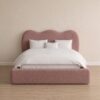 Light pink upholstered wave headboard and padded footboard.
